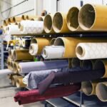 Rows of textile rolls stored in a factory for industrial manufacturing.