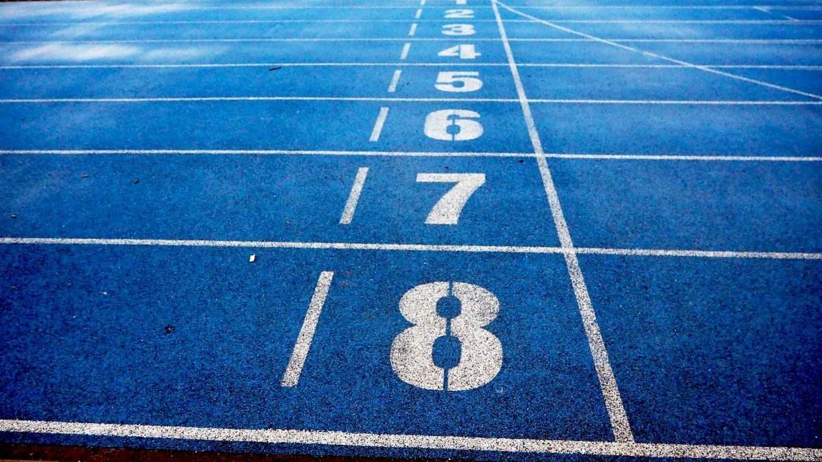 Blue athletic running track with numbered lanes, ideal for sports events and race preparations.