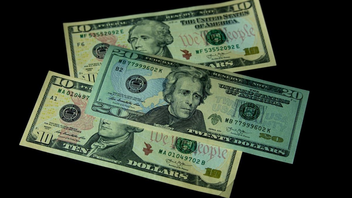 High angle view of US 10 and 20 dollar bills on a black background, emphasizing finance and currency themes.