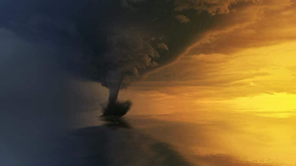 A powerful tornado over the ocean during a dramatic sunset, capturing the storm's intensity and beauty.
