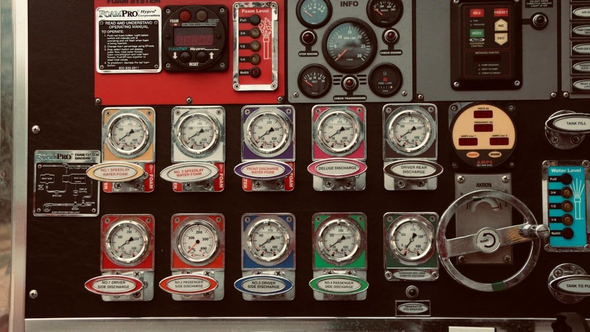 Detailed image of a vintage vehicle control panel with gauges, dials, and labels in a museum or exhibition setting.