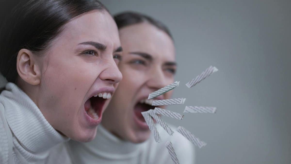 A woman passionately screaming with her reflection in a mirror, artistic concept.