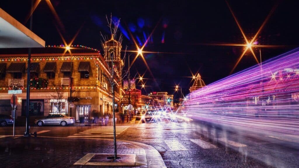Long exposure captures the lively night scene of Kansas City with colorful lights and bustling streets.