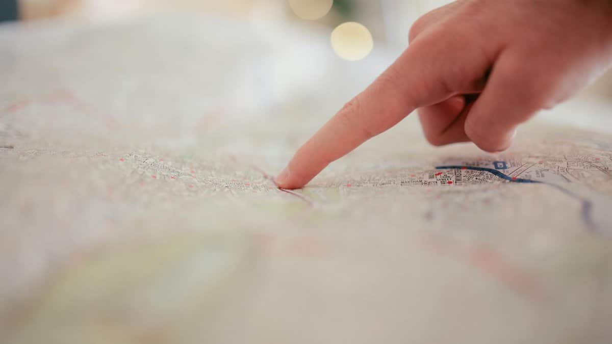 A hand pointing at a city map, highlighting direction and navigation planning.
