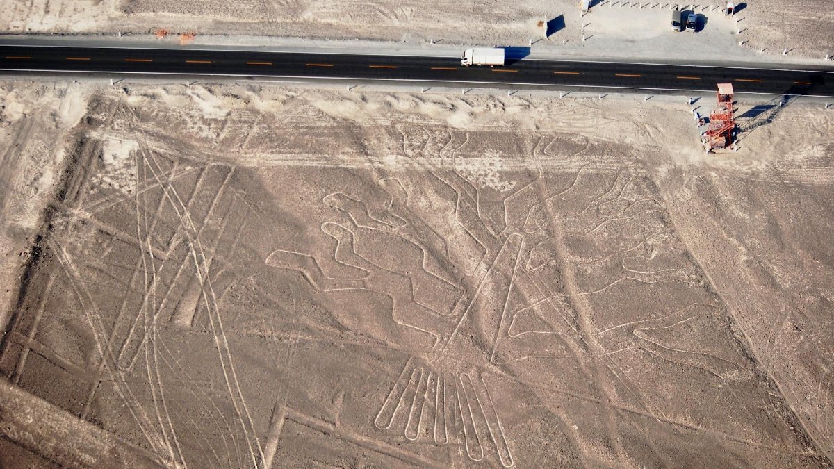 Aerial view showing the ancient Nazca Lines geoglyph in Peru's desert landscape.