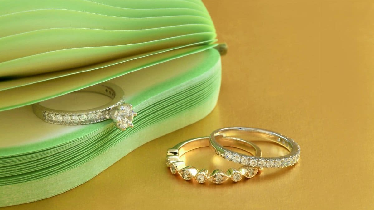 Elegant diamond rings displayed on a gold surface with a chic design.