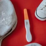 Flat lay of baby shoes, pacifier, and positive pregnancy test symbolizing new beginnings.
