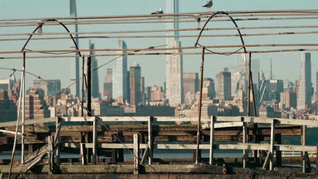 A rustic pier foreground with the vibrant New York City skyline in the background.