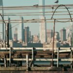 A rustic pier foreground with the vibrant New York City skyline in the background.
