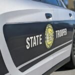 Detailed side view of a North Carolina State Trooper car in a sunny street setting.