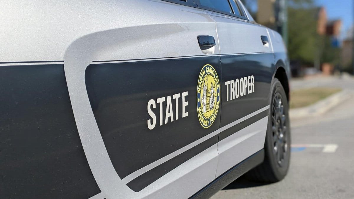 Detailed side view of a North Carolina State Trooper car in a sunny street setting.