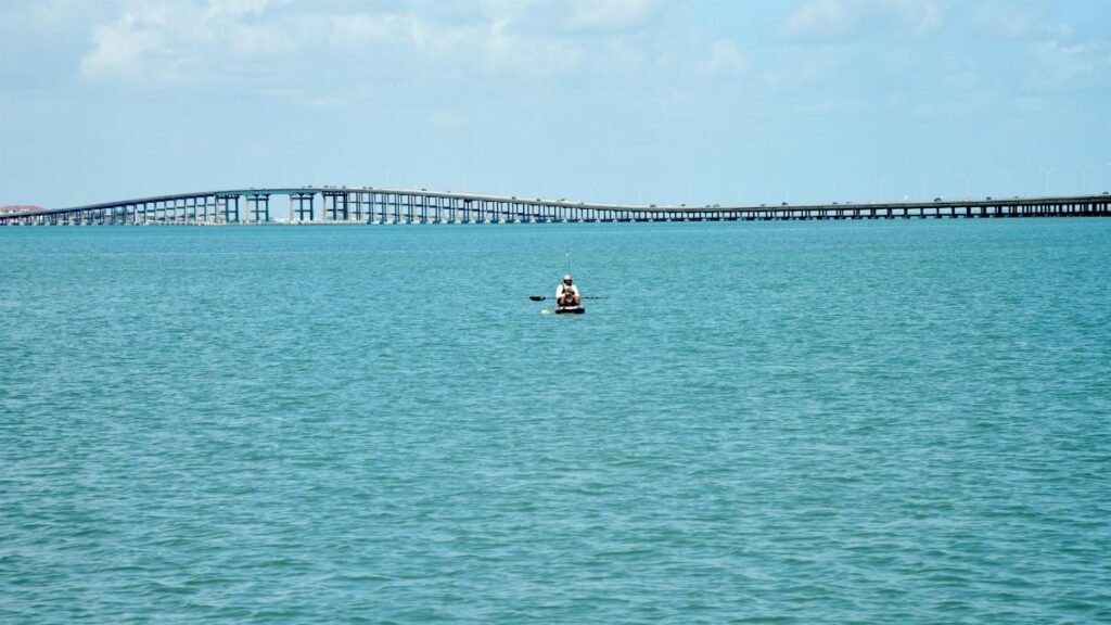 A peaceful day canoeing on the sea with a bridge in the background at South Padre Island, Texas.