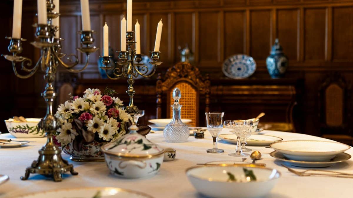 Luxurious dining setting in a historic Łódź palace featuring ornate cutlery and classic decor.