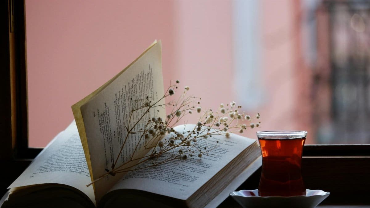 A book with baby's breath and a cup of tea on a</div>