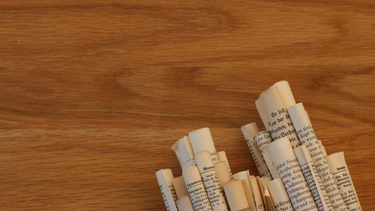 Rolled paper scrolls arranged on a wooden tabletop, showcasing a minimal design.