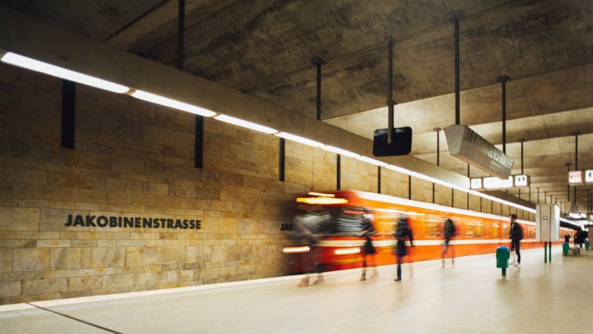 Blurred scene of an orange train speeding through Jakobenstrasse subway station in Fürth, Germany.