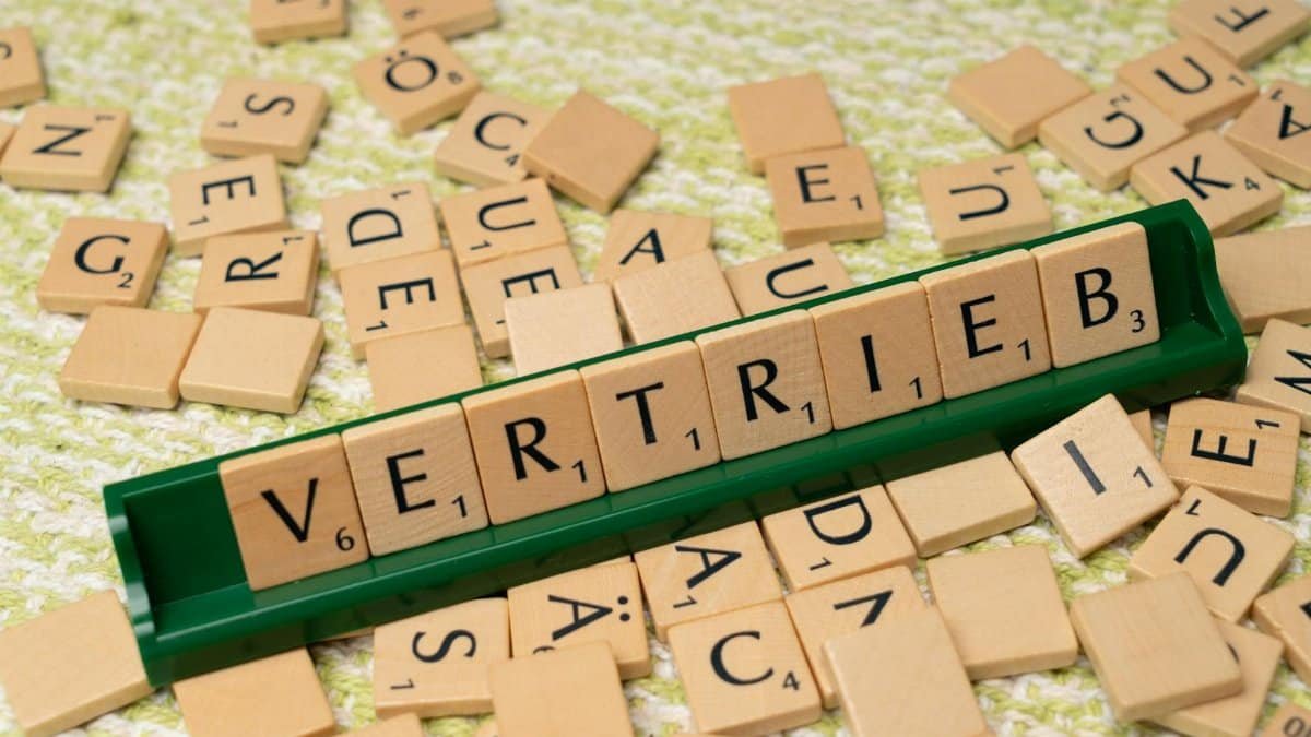Close-up of Scrabble tiles spelling 'Vertrieb', showcasing language learning and play.