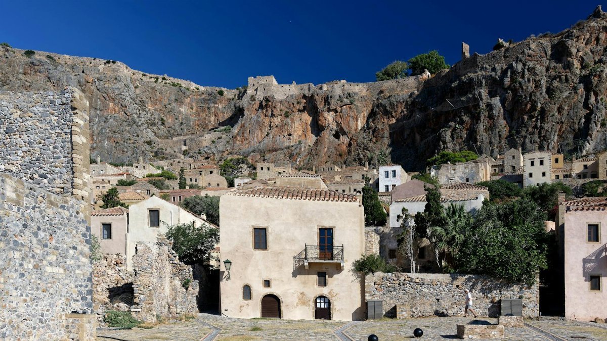 Stone buildings in Monemvasia, Greece showcasing historic architecture against a rocky backdrop.