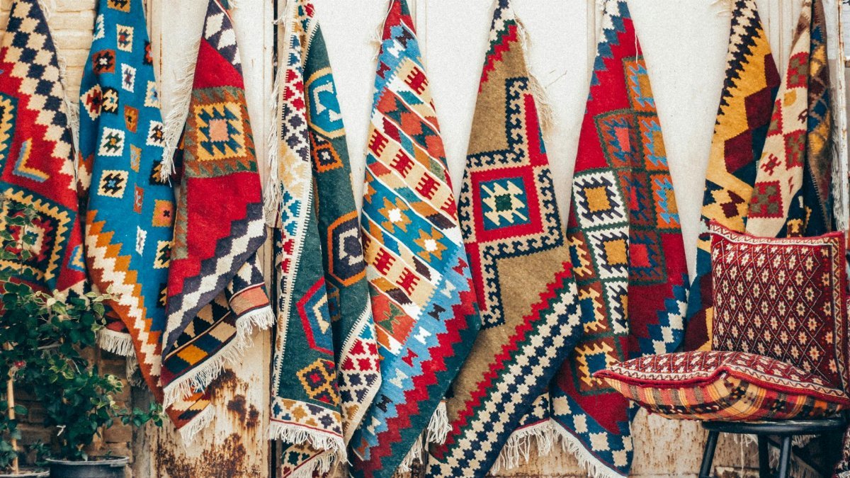 Vibrant Persian rugs hung for display in Shiraz, showcasing traditional Iranian craftsmanship.