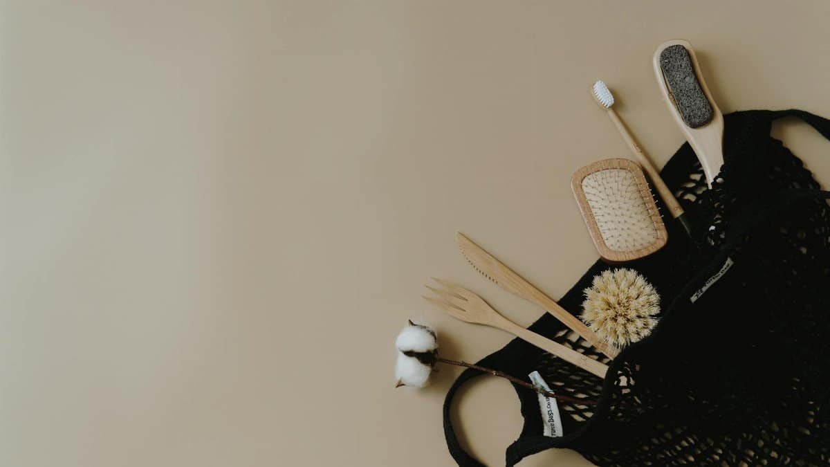 Flat lay of zero waste personal care items in a mesh bag on a neutral background.