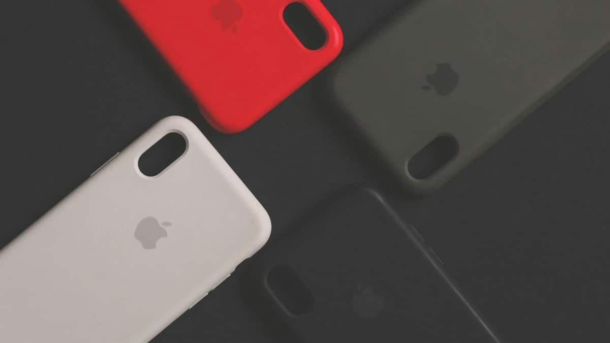 Four colorful smartphone cases on a dark surface, showcasing variety and design.