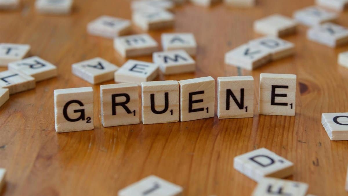 Close-up of wooden letter tiles spelling 'Gruene' on a wood table surface.