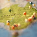 Close-up of a map of Australia with colorful pins marking various cities and destinations.