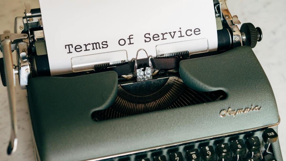 Close-up of a vintage typewriter printing 'Terms of Service' on paper, ideal for legal and business themes.