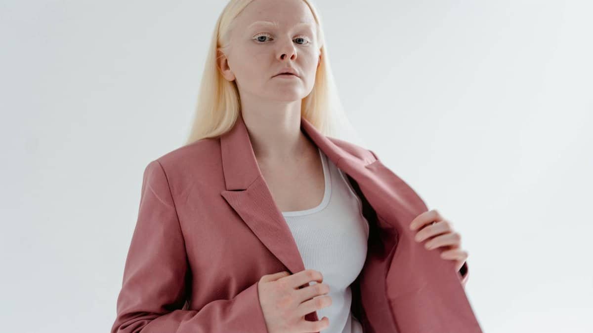 Studio portrait of a confident woman in a pink blazer, symbolizing individuality and style.
