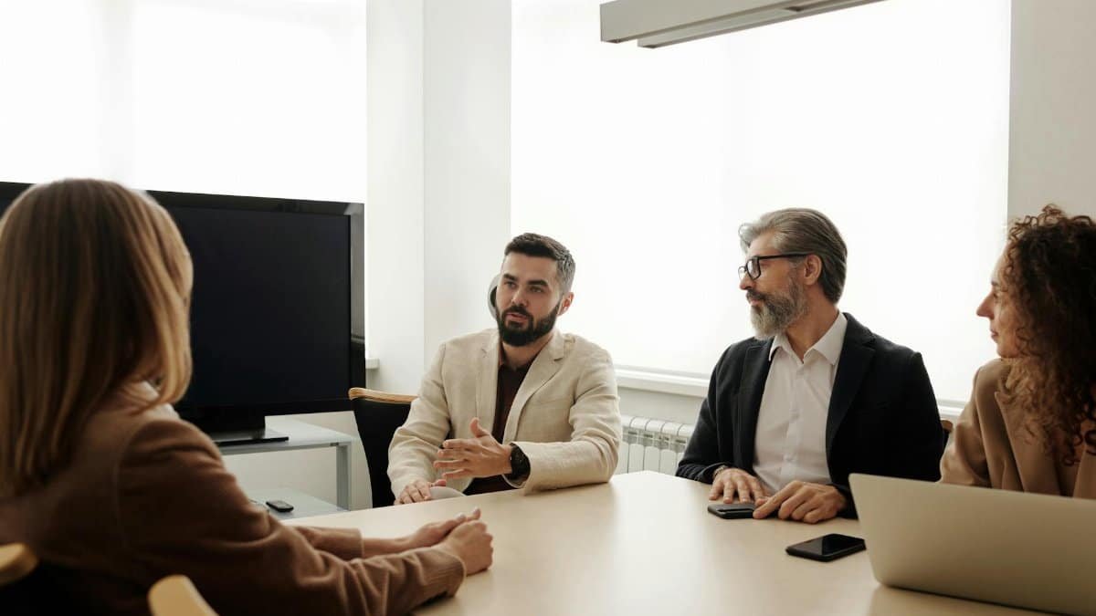 A diverse group of business professionals engaged in a meeting in an office setting.