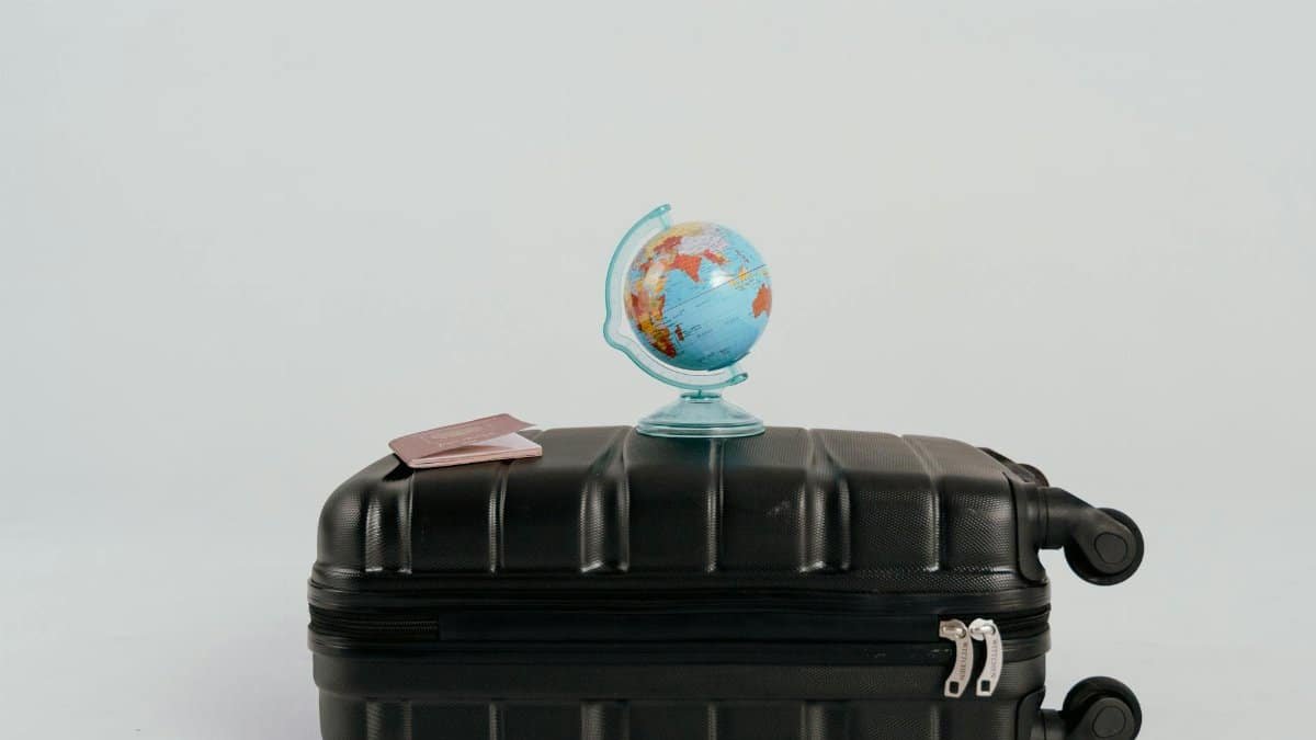 A globe placed on a black suitcase symbolizing global travel and adventure.