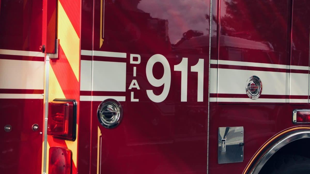 Close-up shot of a firetruck's door featuring the 911 emergency number.