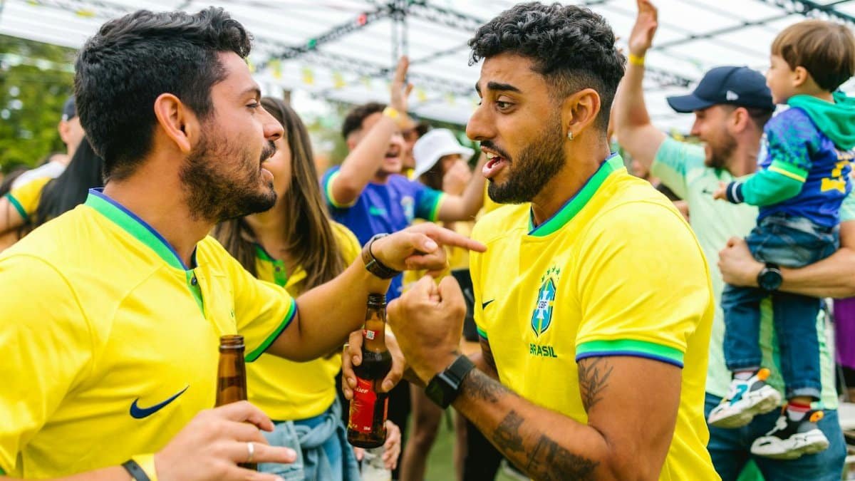 Cheerful soccer fans in yellow jerseys celebrating outdoors with excitement and joy.