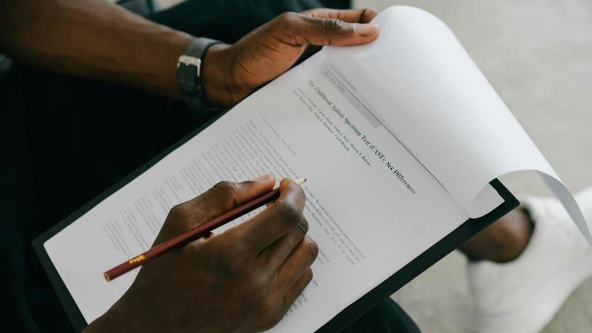 Close-up of a person writing on a psychological assessment form with a pencil.