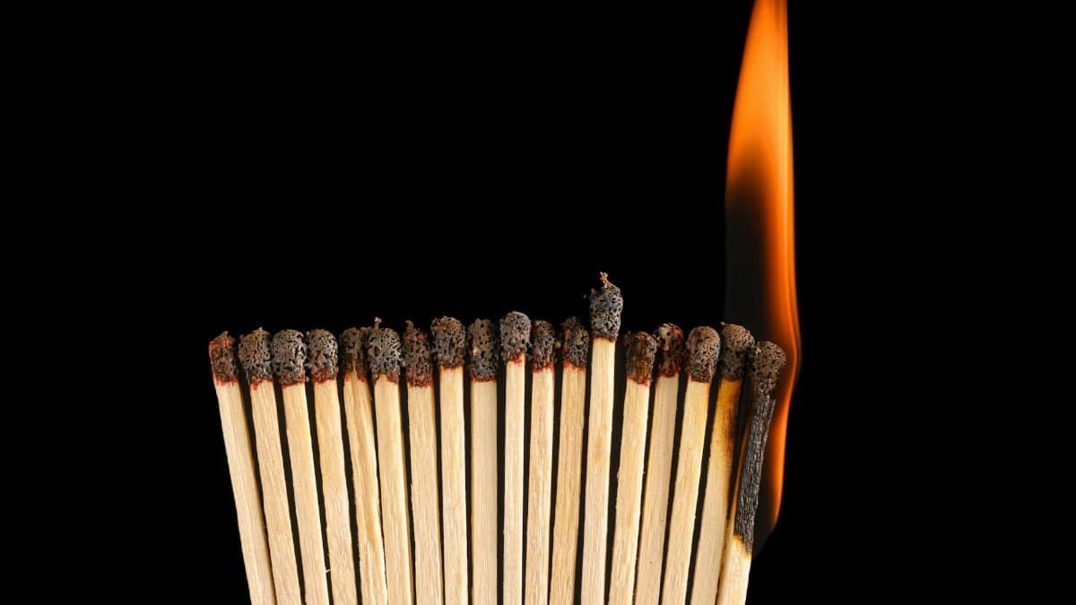 A striking close-up of matchsticks igniting in chain reaction, symbolic of spreading ideas.