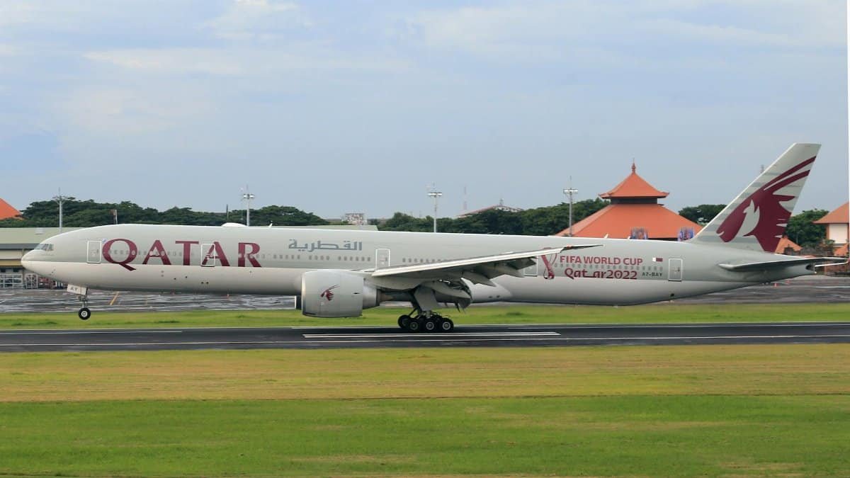 Qatar Airways airplane featuring FIFA World Cup 2022 logo landing on a runway.