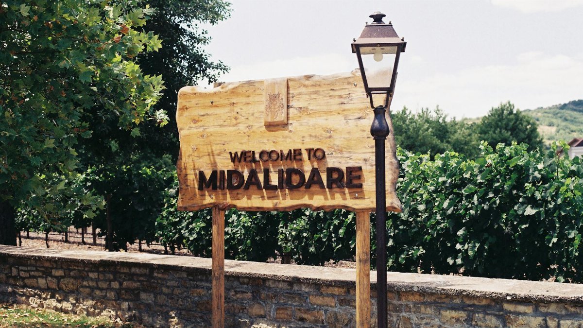 Welcome sign at Midalidare Vineyard with lush greenery background.