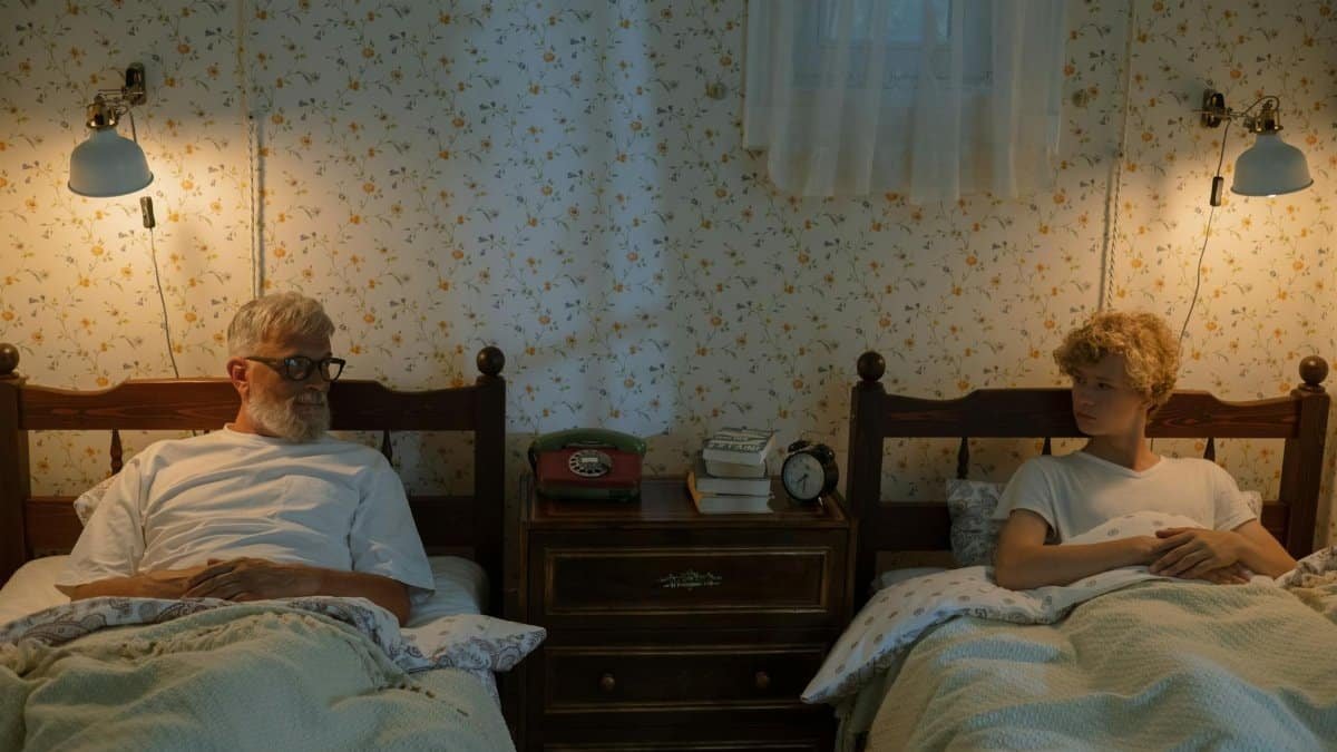 A grandfather and grandson sharing stories in their cozy bedroom at night.