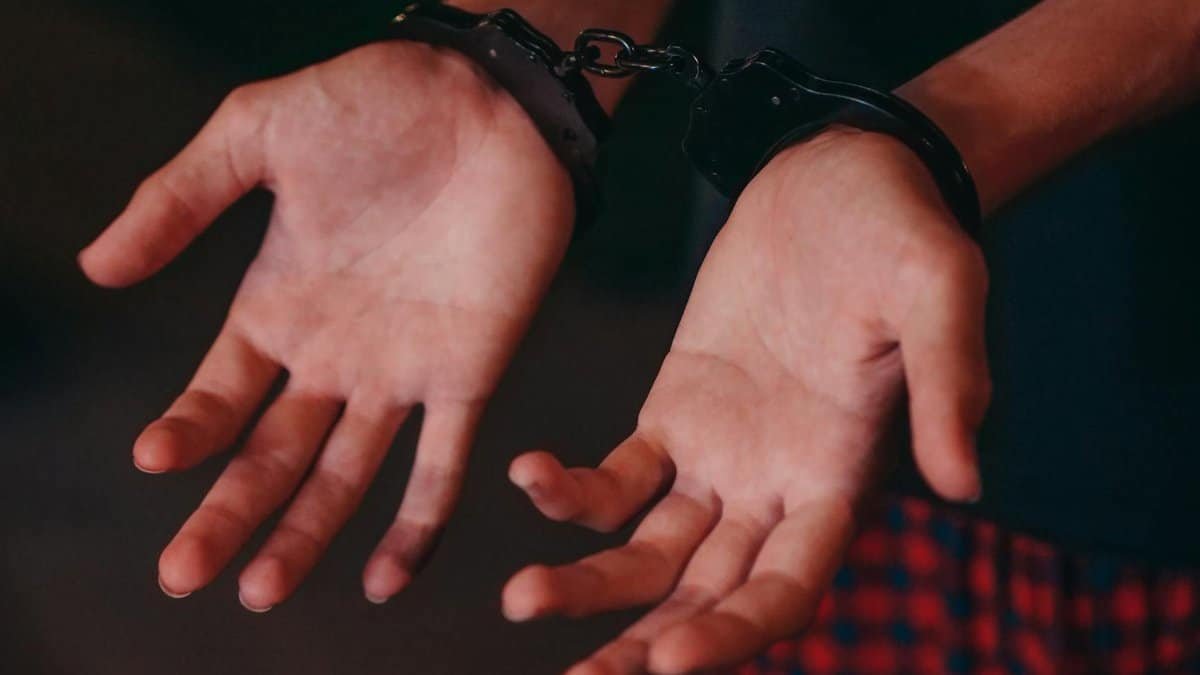 A close-up image showing hands in handcuffs, symbolizing justice and law enforcement.