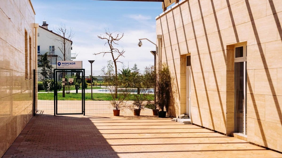 A bright, minimalistic courtyard with modern architecture in Sochi, Russia, featuring clean lines and potted plants.