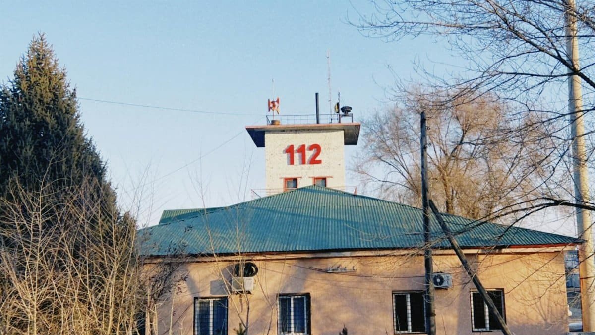 Fire station building with tower and 112 sign in winter, Konaev, Kazakhstan.