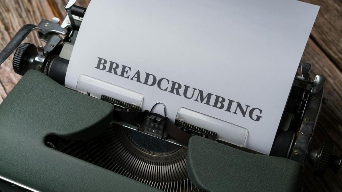 Close-up of a vintage typewriter printing the word 'BREADCRUMBING' on paper.
