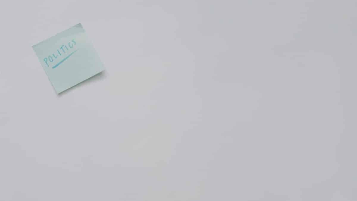 A simple sticky note with 'politics' written on it, offering ample copyspace.