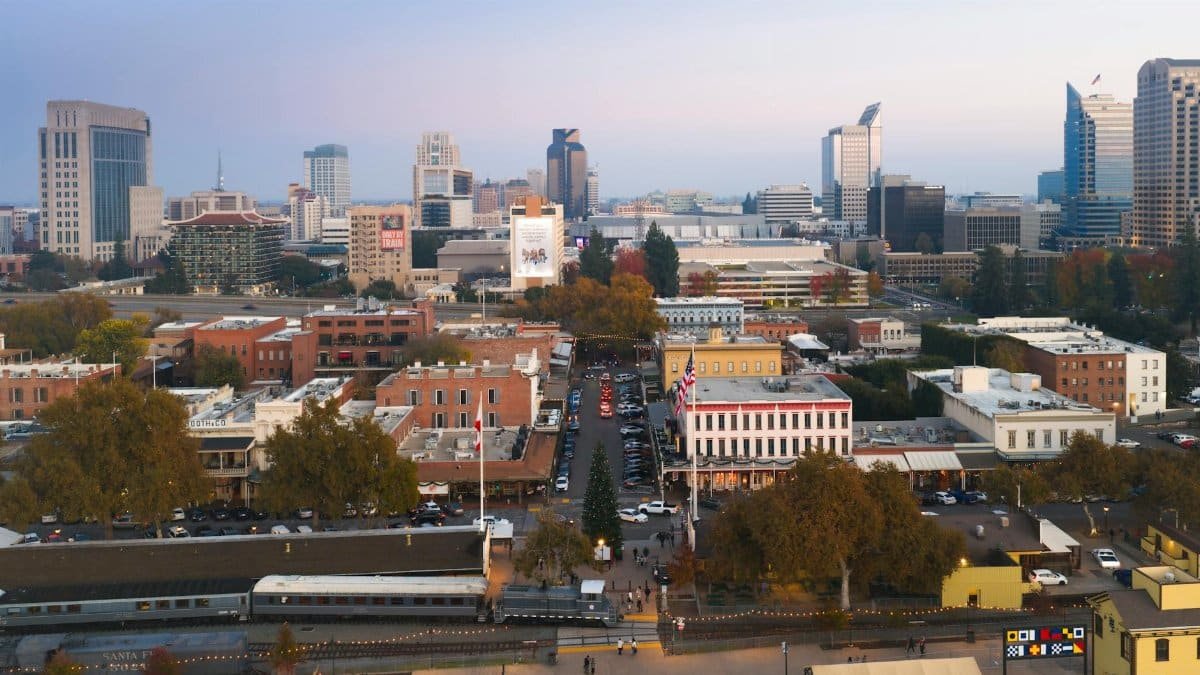 Aerial view of Sacramento cityscape featuring downtown skyline and historic buildings during twilight.
