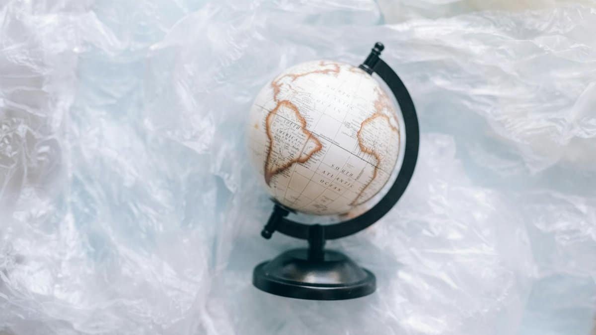 A globe wrapped in plastic symbolizes environmental issues and the need for sustainability.