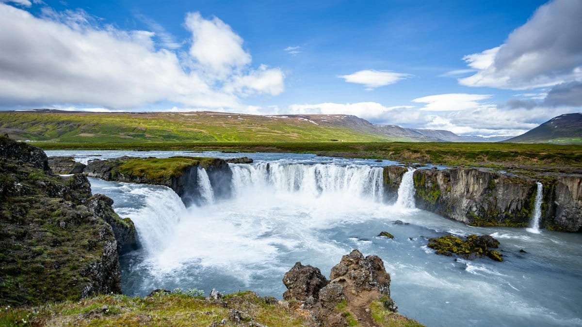 Breathtaking view of the powerful Godafoss waterfall in Iceland surrounded by lush landscapes.