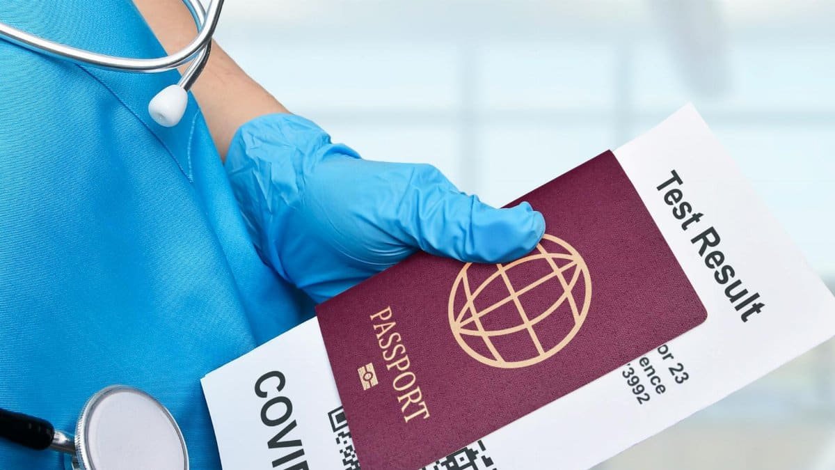 Close-up of a healthcare worker holding a passport and COVID-19 test result, symbolizing travel requirements.