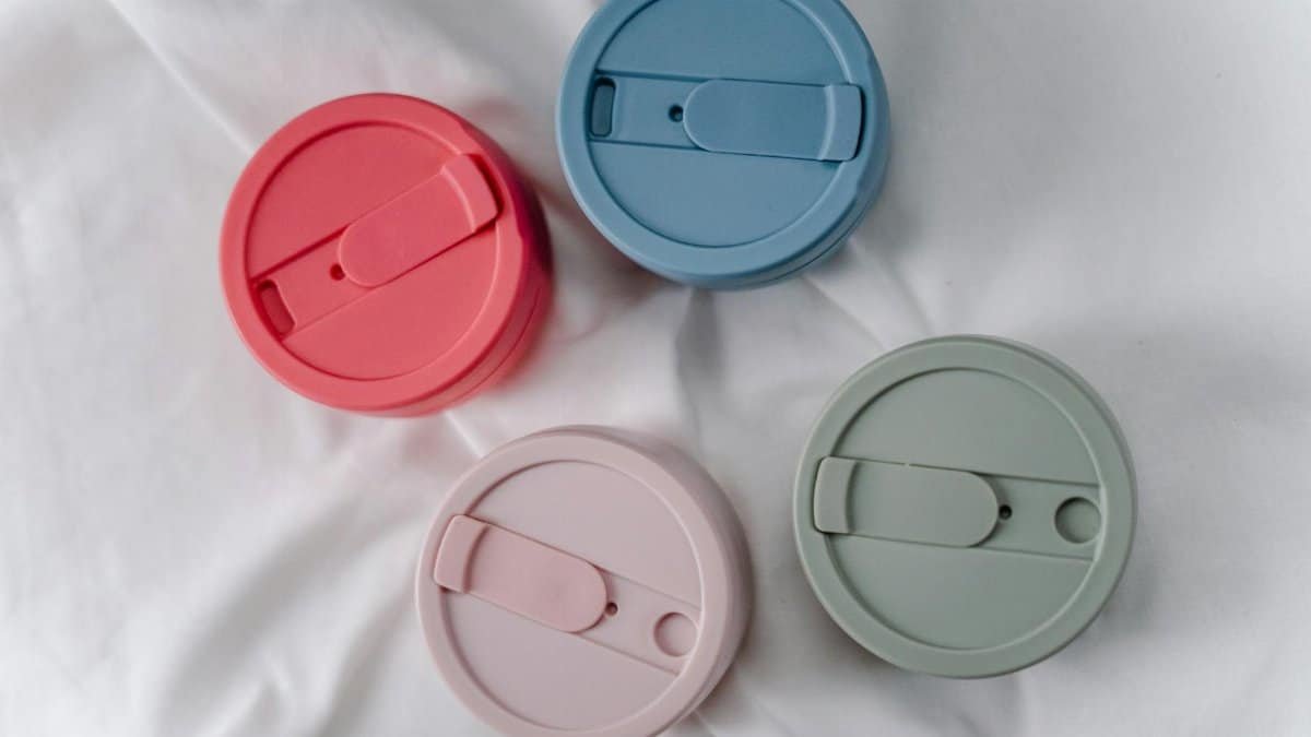 A close-up of four colorful, reusable silicone cup lids promoting zero waste.