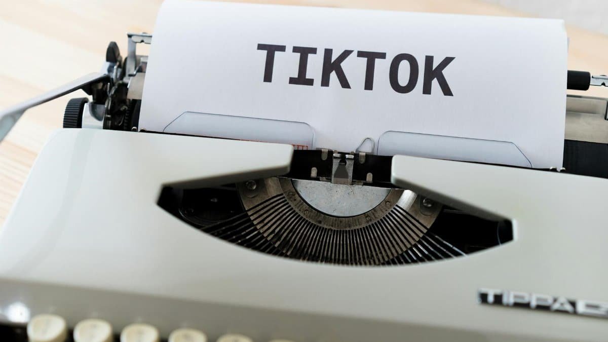 A vintage typewriter holding paper with TikTok written, symbolizing modern social media trends.