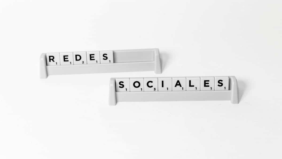 Scrabble tiles arranged to spell 'Redes Sociales', depicting social media on a white background.